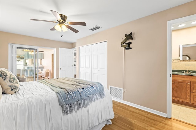 bedroom featuring light wood-type flooring, a closet, ceiling fan, and connected bathroom