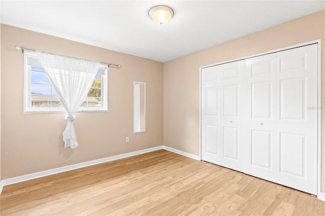 unfurnished bedroom with a closet and light hardwood / wood-style flooring