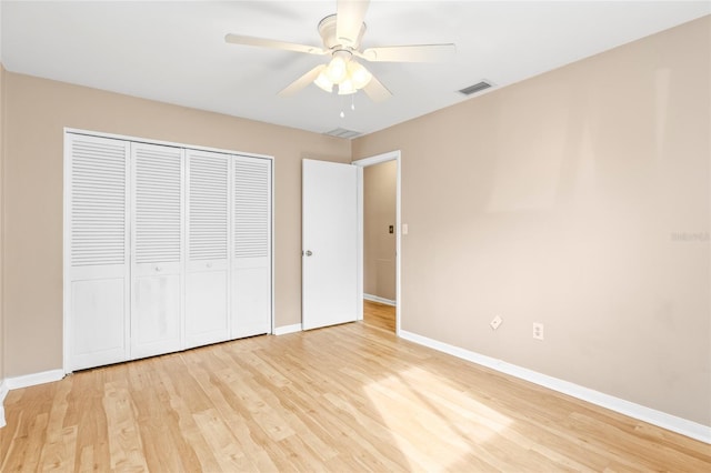 unfurnished bedroom featuring ceiling fan, a closet, and light wood-type flooring