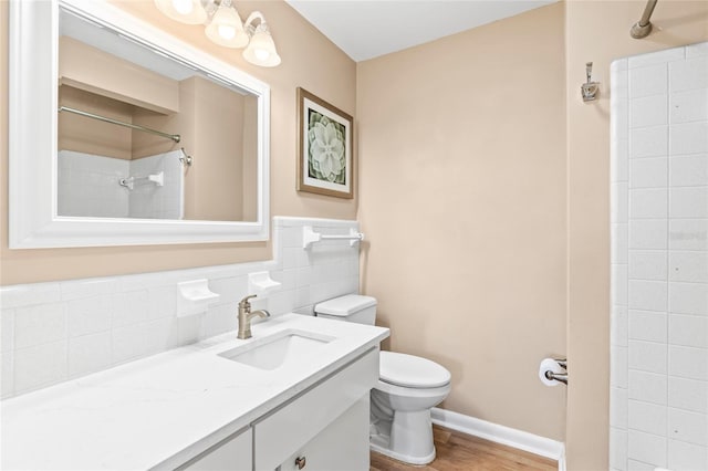 bathroom featuring tasteful backsplash, vanity, a shower, hardwood / wood-style floors, and toilet