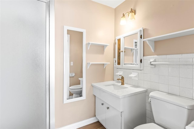 bathroom with wood-type flooring, vanity, toilet, and tile walls