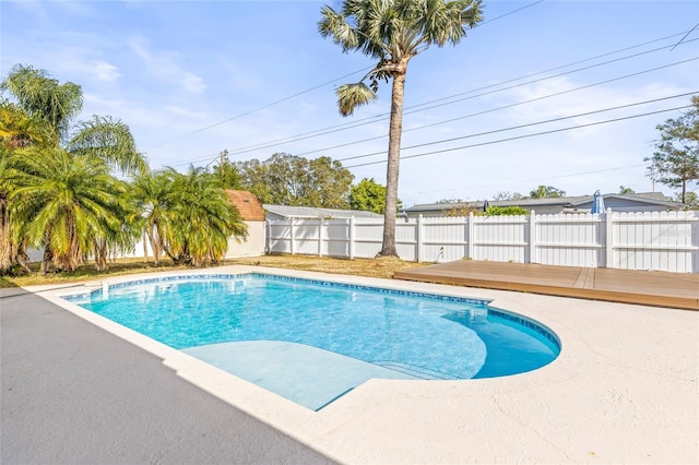 view of pool featuring a patio and a wooden deck