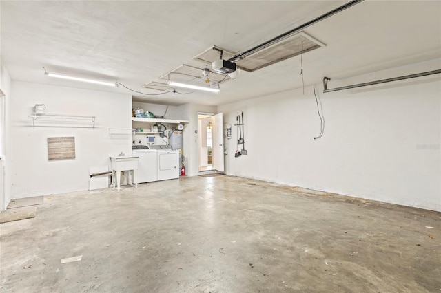 garage with independent washer and dryer, sink, and a garage door opener