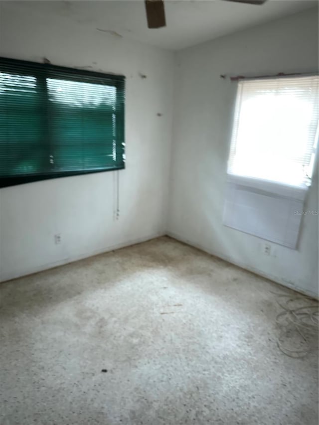 spare room with ceiling fan and a healthy amount of sunlight