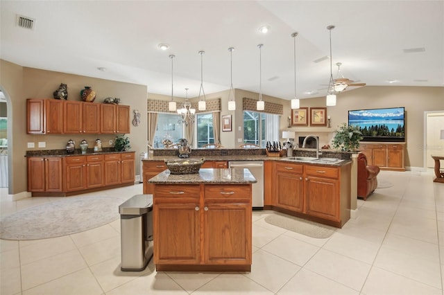 kitchen featuring sink, stainless steel dishwasher, an island with sink, pendant lighting, and ceiling fan with notable chandelier