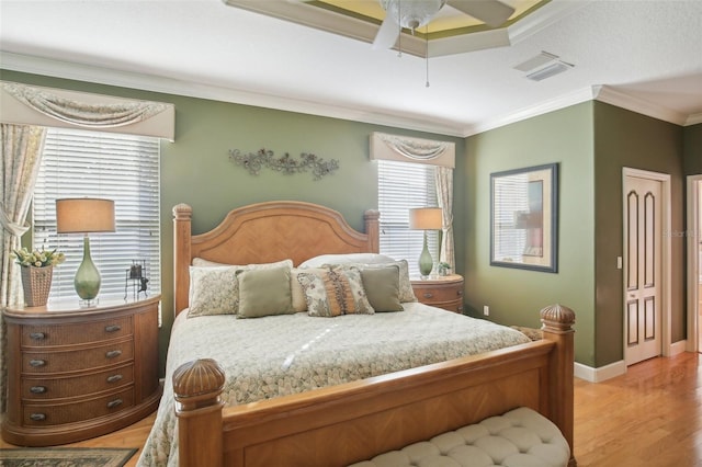 bedroom featuring ceiling fan, crown molding, and light hardwood / wood-style floors