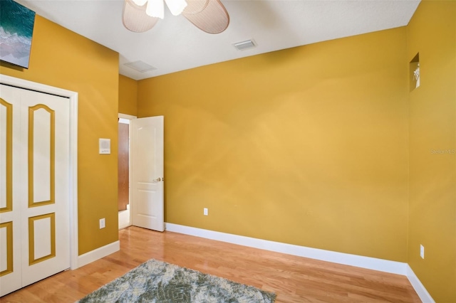 bedroom with wood-type flooring, a closet, and ceiling fan