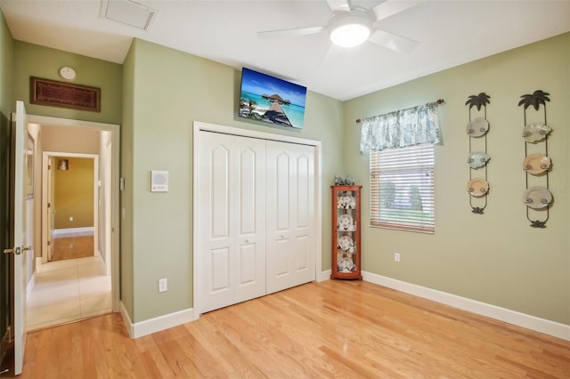 unfurnished bedroom featuring a closet, light hardwood / wood-style floors, and ceiling fan