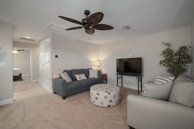 living room featuring ceiling fan, light colored carpet, visible vents, and baseboards