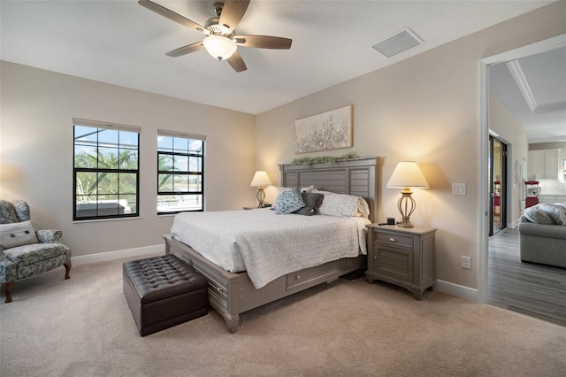 bedroom featuring light colored carpet, ceiling fan, visible vents, and baseboards