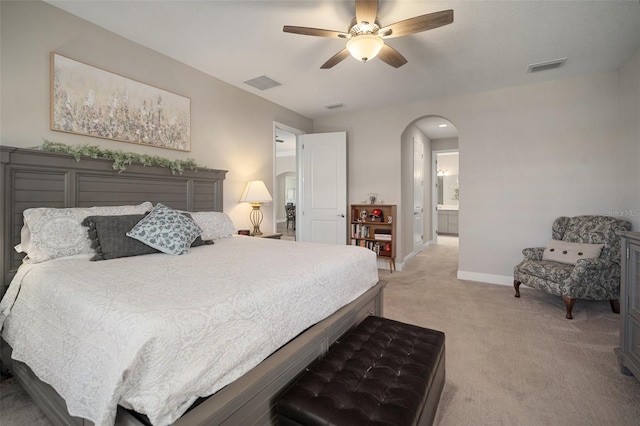 bedroom featuring baseboards, visible vents, arched walkways, and light colored carpet