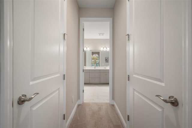 corridor with light colored carpet and baseboards