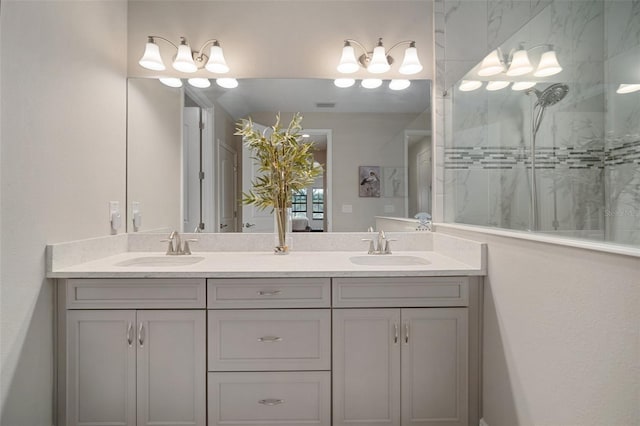 full bath featuring a stall shower, a sink, and double vanity