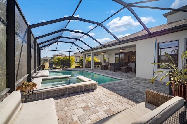 view of pool featuring an outdoor hangout area, glass enclosure, a patio area, and a pool with connected hot tub