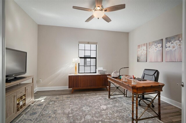 office area featuring a ceiling fan, dark wood-style flooring, and baseboards