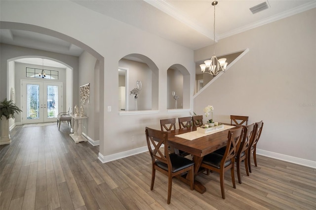 dining area with a notable chandelier, dark wood-type flooring, visible vents, baseboards, and french doors