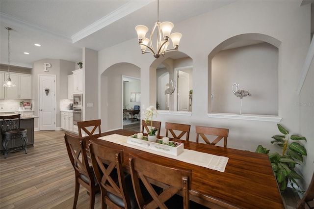 dining area with ornamental molding, light wood-type flooring, an inviting chandelier, and recessed lighting