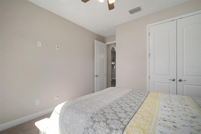 carpeted bedroom with arched walkways, a closet, visible vents, ceiling fan, and baseboards