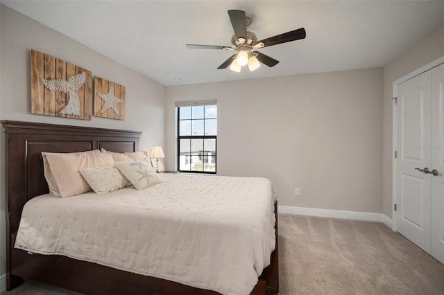 bedroom with ceiling fan, a closet, carpet flooring, and baseboards