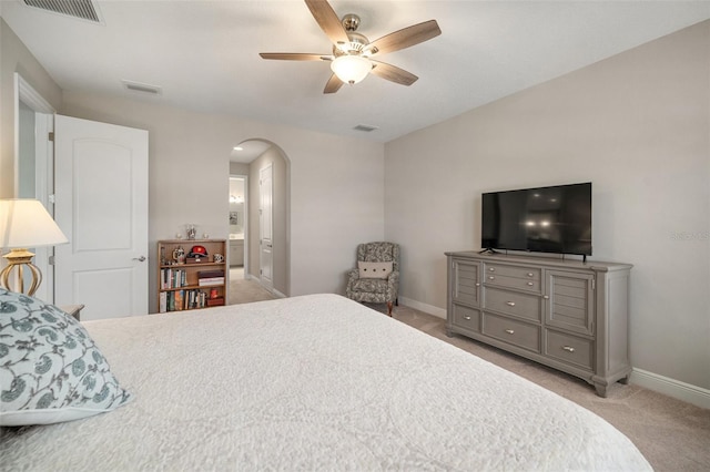 bedroom with arched walkways, baseboards, visible vents, and light colored carpet