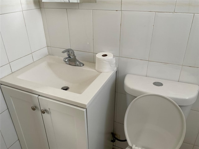 bathroom with decorative backsplash, vanity, and tile walls