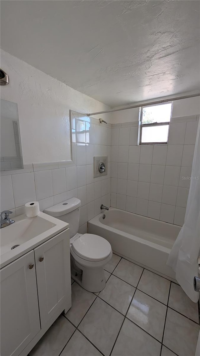 full bathroom featuring vanity, shower / tub combo with curtain, tile walls, tile patterned flooring, and toilet