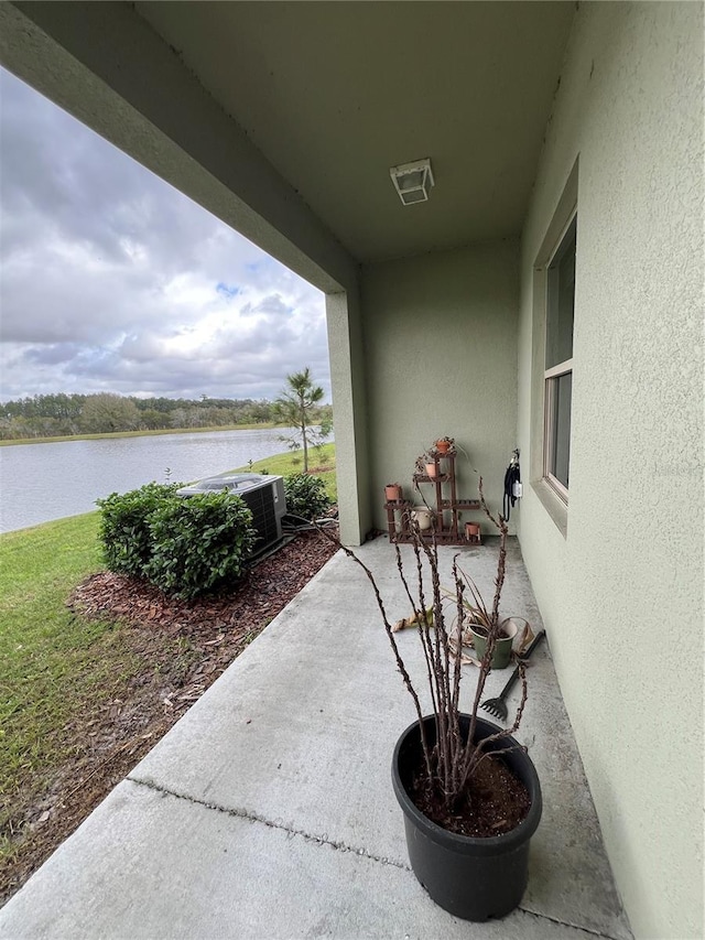 view of patio featuring cooling unit and a water view