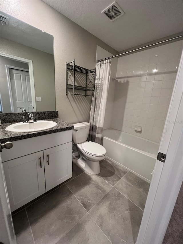 full bathroom featuring a textured ceiling, vanity, shower / tub combo with curtain, tile patterned flooring, and toilet