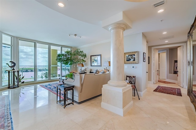 living room featuring expansive windows, ornamental molding, light tile patterned floors, and decorative columns