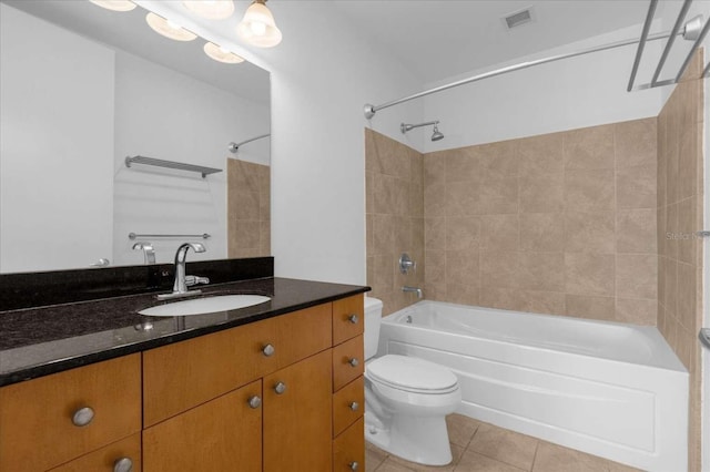 full bathroom with tile patterned flooring, tiled shower / bath combo, toilet, and vanity