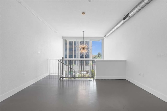 empty room with a chandelier, floor to ceiling windows, and ornamental molding