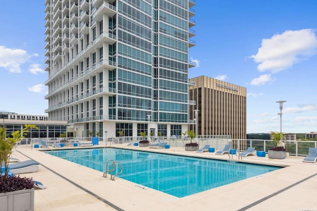 community pool with fence and a patio