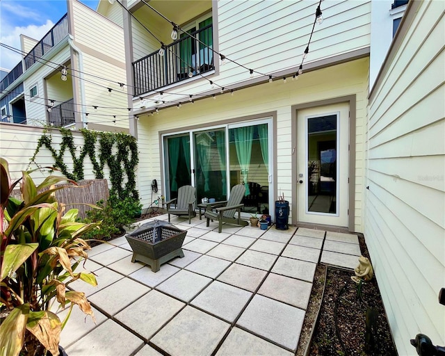 view of patio featuring a balcony and a fire pit