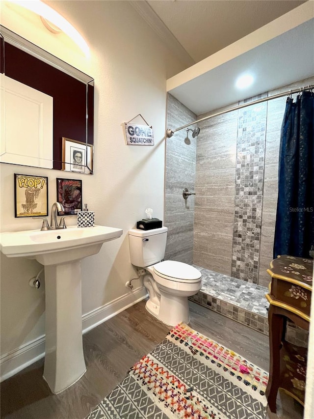 bathroom featuring sink, walk in shower, crown molding, hardwood / wood-style floors, and toilet