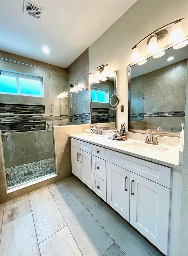 bathroom featuring vanity, an enclosed shower, and tile walls