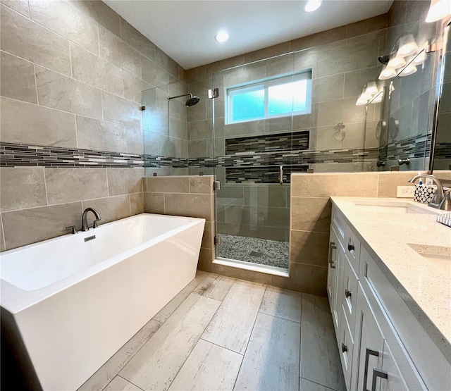 bathroom with vanity, tile walls, and plus walk in shower