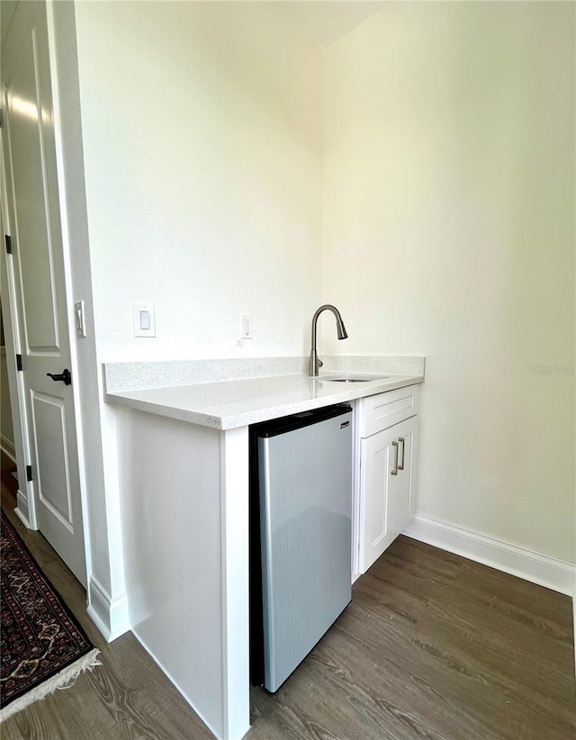 kitchen featuring stainless steel fridge, dark wood-type flooring, and sink