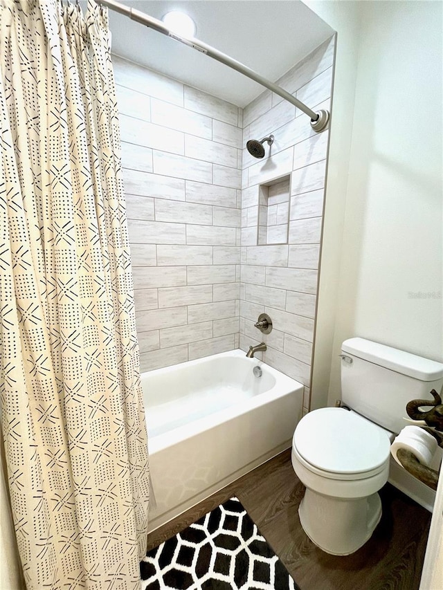 bathroom with hardwood / wood-style floors, toilet, and shower / tub combo with curtain