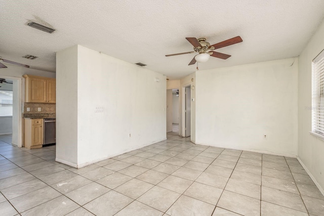 tiled spare room featuring ceiling fan and a textured ceiling