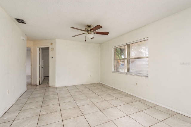 empty room with light tile patterned floors, a textured ceiling, and ceiling fan