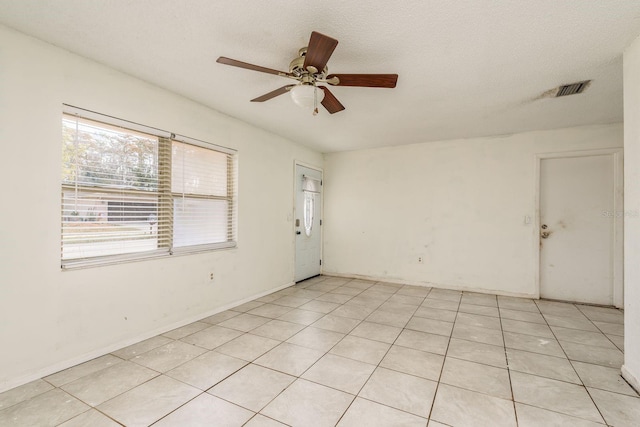 unfurnished room featuring light tile patterned floors, a textured ceiling, and ceiling fan