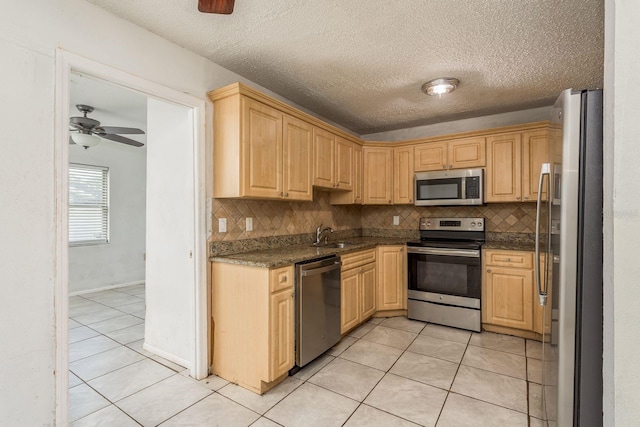 kitchen featuring tasteful backsplash, ceiling fan, light tile patterned flooring, and stainless steel appliances