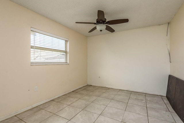 tiled spare room with ceiling fan and a textured ceiling