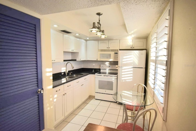 kitchen with sink, light tile patterned floors, pendant lighting, white appliances, and white cabinets