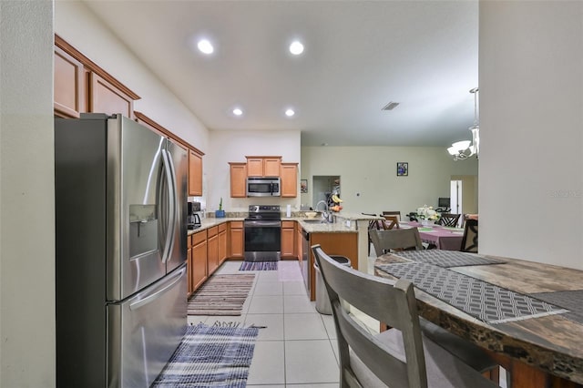 kitchen featuring sink, a notable chandelier, decorative light fixtures, light tile patterned floors, and appliances with stainless steel finishes