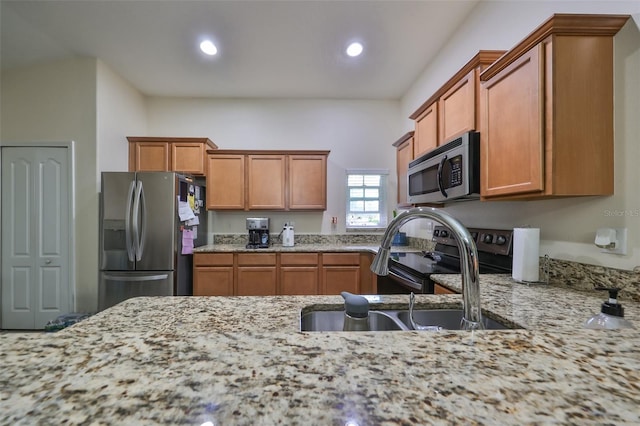 kitchen featuring light stone counters, sink, and stainless steel appliances