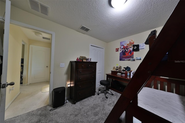 carpeted bedroom with a closet and a textured ceiling