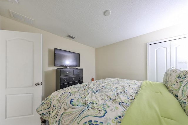 bedroom with a textured ceiling and a closet