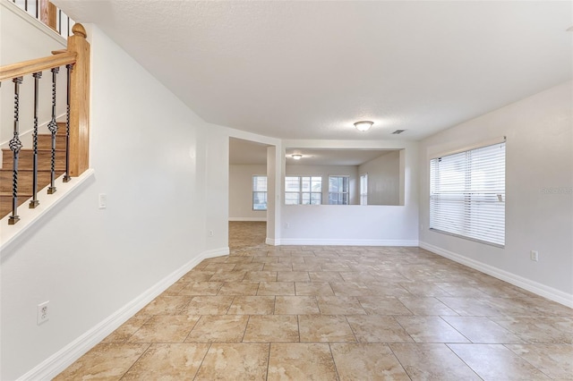 empty room with a textured ceiling and plenty of natural light