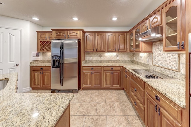 kitchen featuring black electric cooktop, light stone countertops, stainless steel refrigerator with ice dispenser, and decorative backsplash